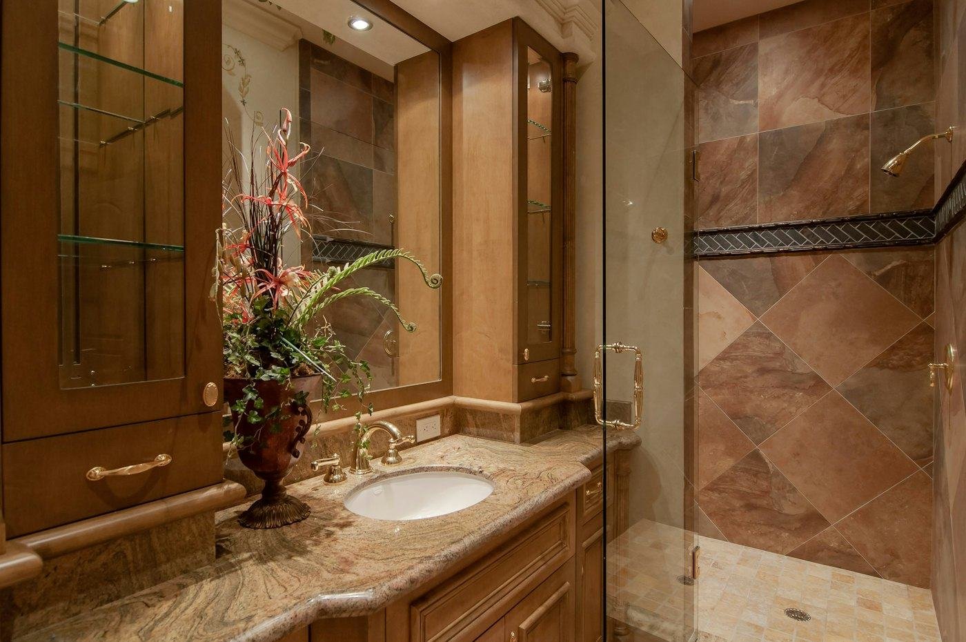Bathroom with tile shower and stone vanity top
