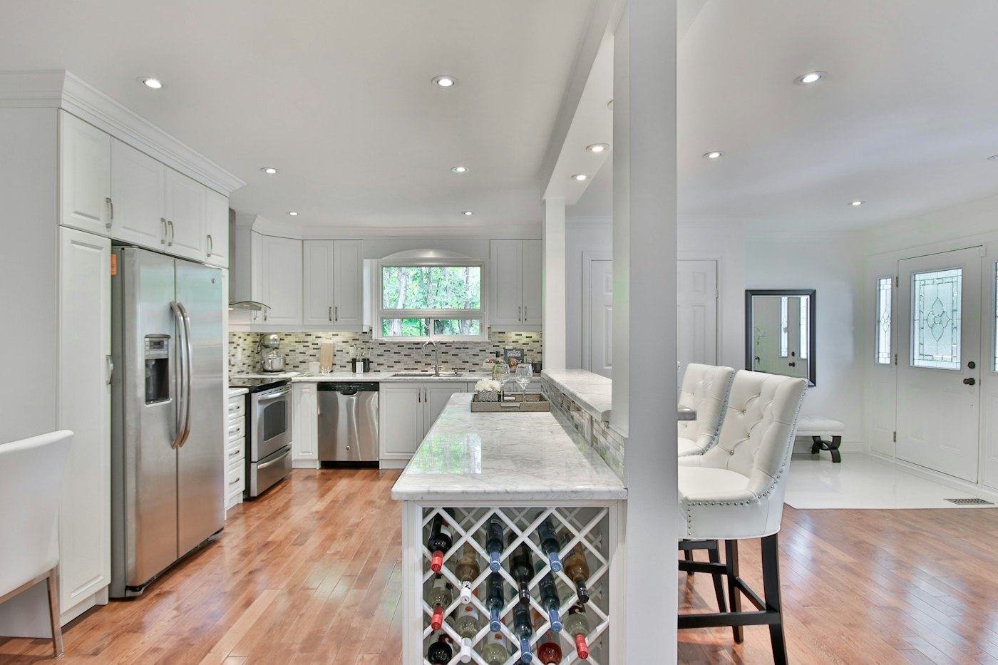 Open kitchen with island seating and white counters